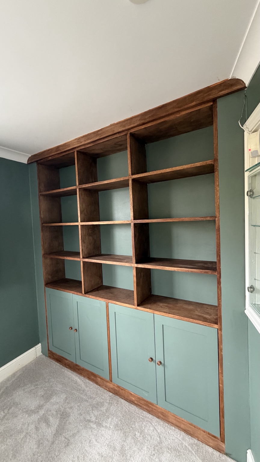 Bespoke shelving with green shaker cabinets and timber framing