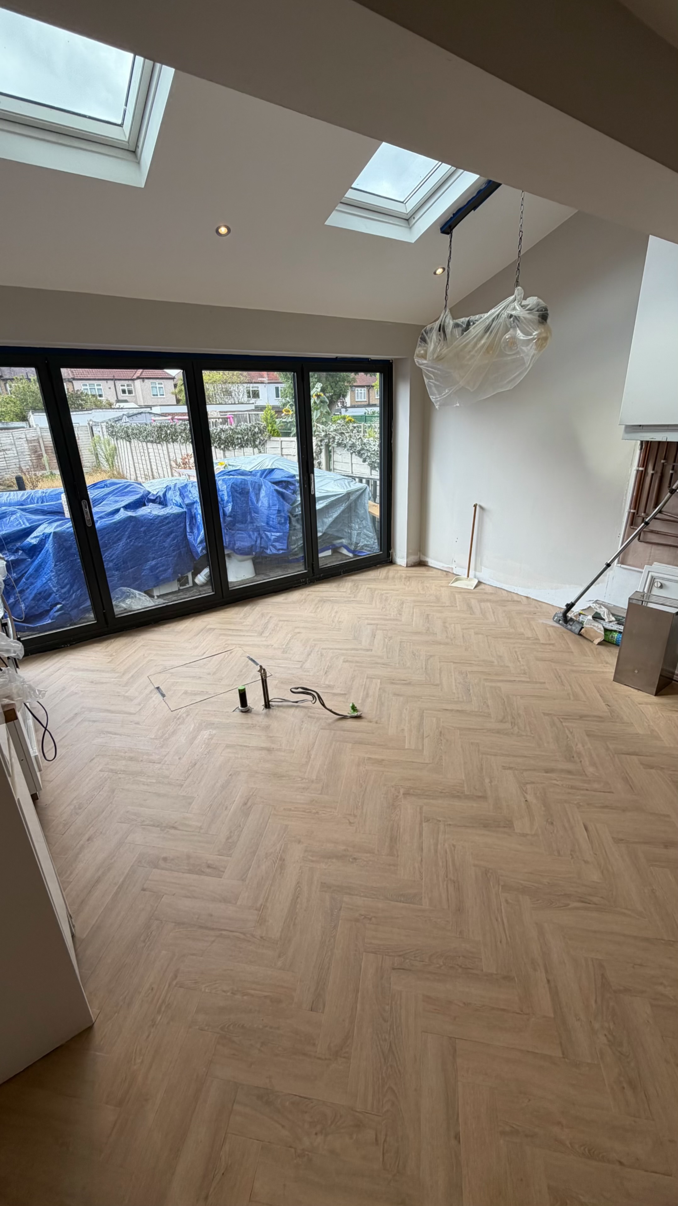 Light oak herringbone flooring across an open-plan room