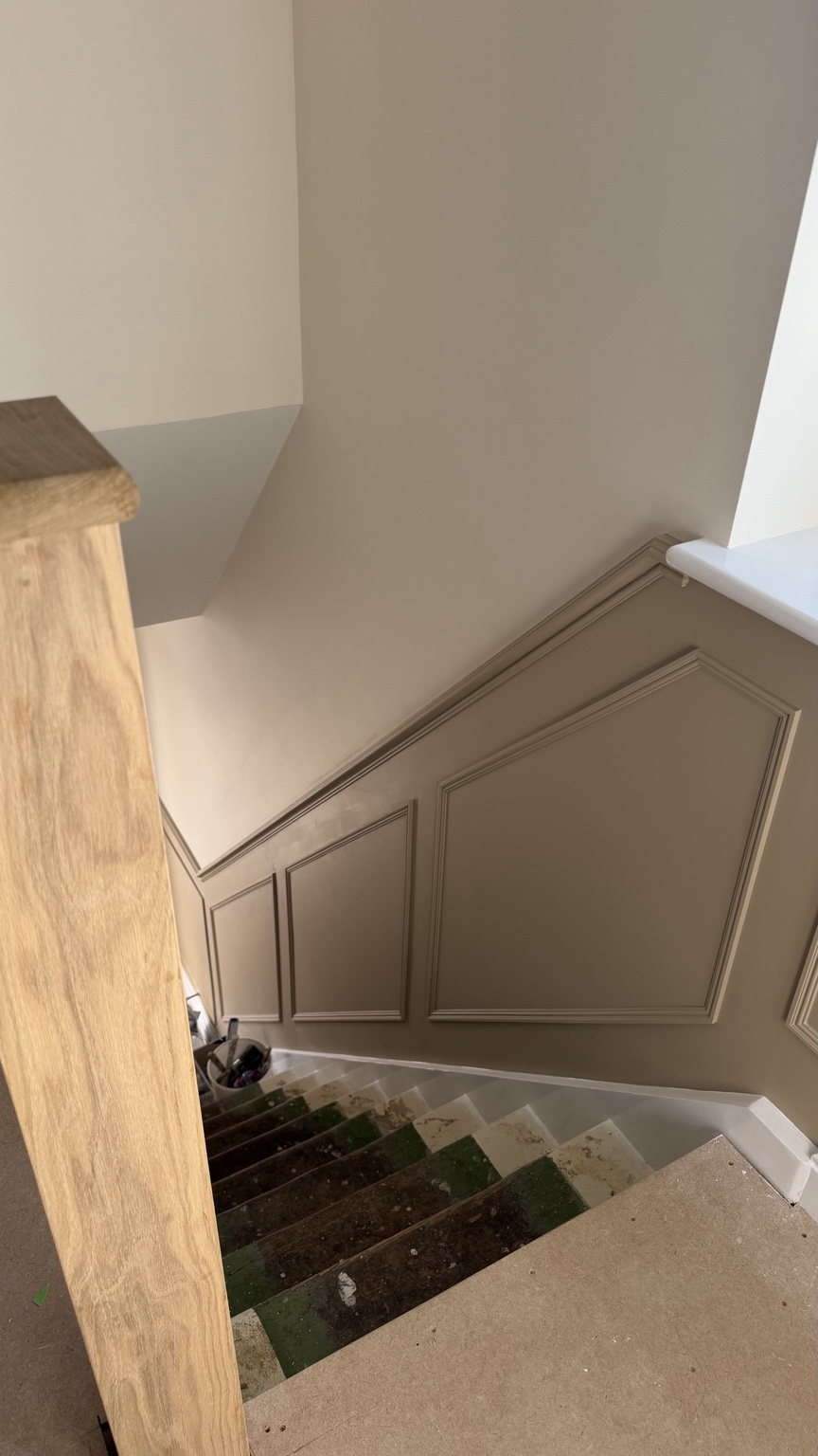 Decorative stair wall panelling in a warm neutral interior